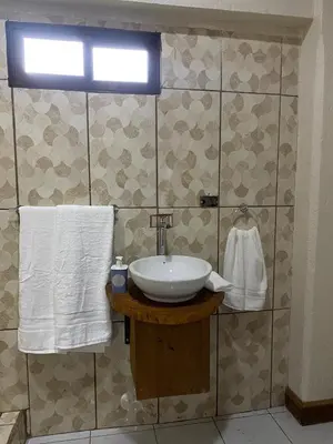 a bathroom with a sink and towels on a wall at Casa 1856- cómodas habitaciones en el Centro de Alajuela in Alajuela City