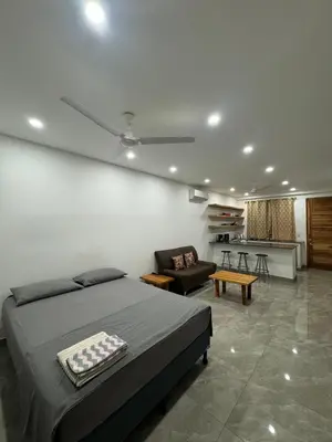 a bedroom with a bed and a couch and a chair at Hotel Bella Tamarindo Guanacaste in Tamarindo