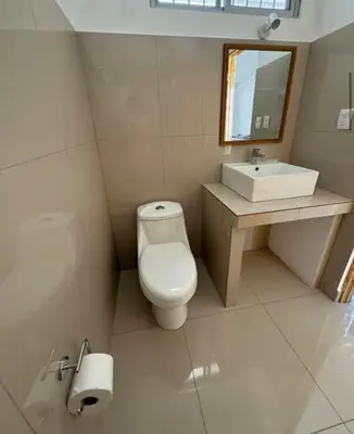 a bathroom with a toilet and a sink at Hotel Bella Tamarindo Guanacaste in Tamarindo