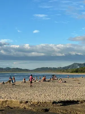 a group of people sitting on a beach at Hotel Bella Tamarindo Guanacaste in Tamarindo