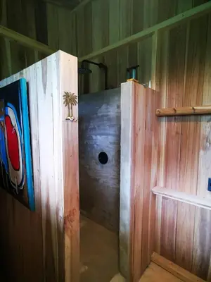 a wooden shower with a door in a room at Papaya Lodge in Bijagua