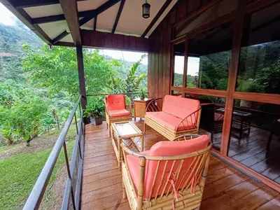 a screened in porch with chairs and a table at Aloha chirripo cabaña familiar in Convento