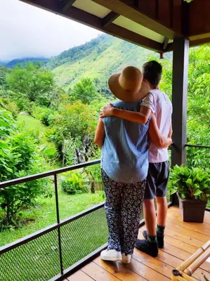 a man and a woman standing on a porch looking at a view at Aloha chirripo cabaña familiar in Convento