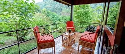 a balcony with chairs and a view of the forest at Aloha chirripo cabaña familiar in Convento