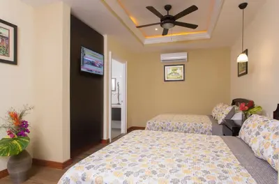 a bedroom with two beds and a ceiling fan at Airport Costa Rica B&B in Alajuela City