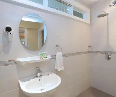 a bathroom with a sink and a mirror at Airport Costa Rica B&B in Alajuela City