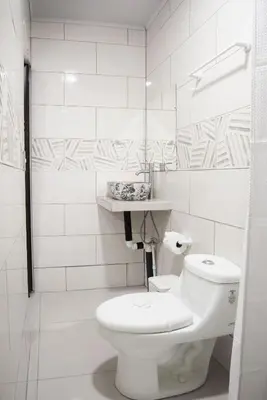 a white bathroom with a toilet and a sink at Casa DesKanso - La Fortuna in Fortuna