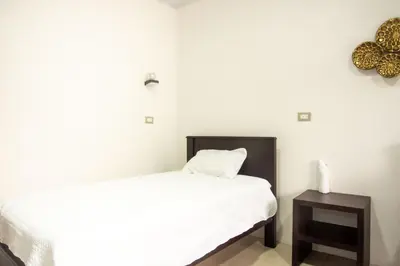 a small bedroom with a bed and a night stand at Casa DesKanso - La Fortuna in Fortuna
