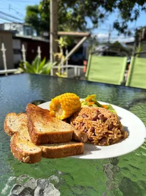 a plate of food with bread and corn on a table at Marianas Apartments 5MIN SJO AIRPORT in Alajuela City