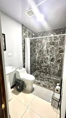 a bathroom with a toilet and a shower at Marianas Apartments 5MIN SJO AIRPORT in Alajuela City