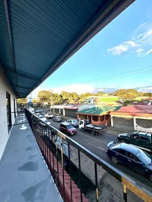 a view of a parking lot with cars parked on the street at Marianas Apartments 5MIN SJO AIRPORT in Alajuela City