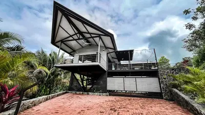 a house with a balcony on top of a brick floor at Casa Ker Lumar in Uvita