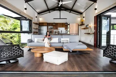a woman sitting on a couch in a living room at Casa Ker Lumar in Uvita