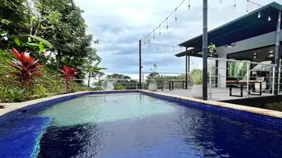 a large blue swimming pool in front of a house at Casa Ker Lumar in Uvita