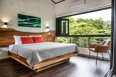 a bedroom with a large bed and a large window at Casa Ker Lumar in Uvita