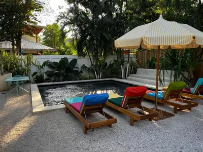 a group of chairs and an umbrella next to a pool at The Beach Break Surf Hotel in Nosara