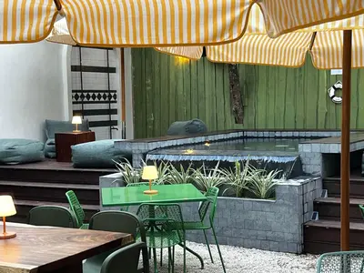 a patio with a table and chairs and a hot tub at The Beach Break Surf Hotel in Nosara