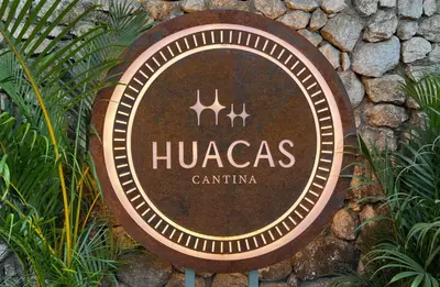 a sign that says hucas cantina on a stone wall at The Beach Break Surf Hotel in Nosara
