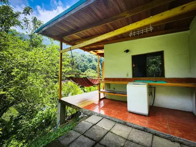a house with a counter and a refrigerator on a patio at Cloudbridge Nature Reserve in Herradura
