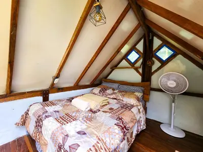 a bedroom with a bed in a attic at Cloudbridge Nature Reserve in Herradura