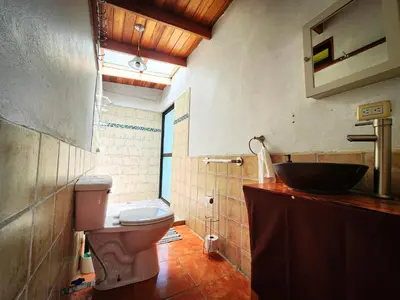 a bathroom with a toilet and a sink at Cloudbridge Nature Reserve in Herradura
