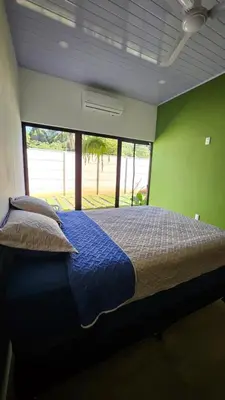 a bedroom with a blue bed with a green wall at Nuevo Leones, #50 in Parrita