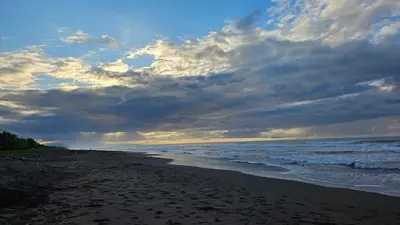 a beach with a cloudy sky and the ocean at Nuevo Leones, #50 in Parrita