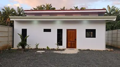 a white house with a brown door on it at Nuevo Leones, #50 in Parrita