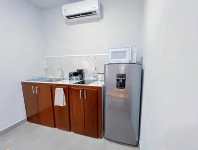 a kitchen with a refrigerator and a microwave at Forest apartments studio F2, walking to the beach in Jacó