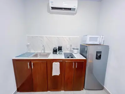 a small kitchen with a sink and a refrigerator at Forest apartments studio F2, walking to the beach in Jacó