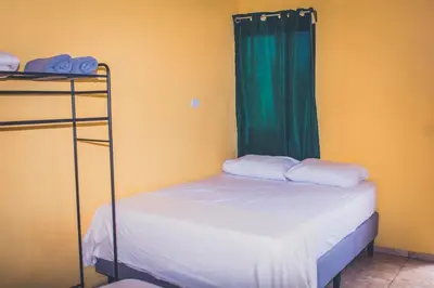a bedroom with two bunk beds and a green curtain at Cabinas Cóbano - Florida in Tambor