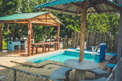a pool with a pavilion and a picnic table and a picnic table at Cabinas Cóbano - Florida in Tambor