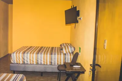 a room with a bed and a desk with a chair at Cabinas Cóbano - Florida in Tambor