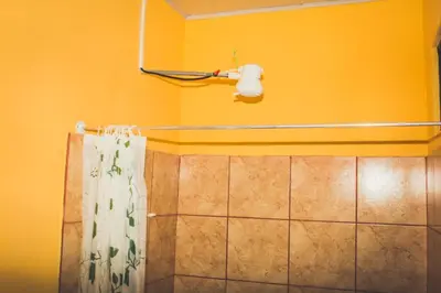 a bathroom with a shower curtain and a blow dryer at Cabinas Cóbano - Florida in Tambor