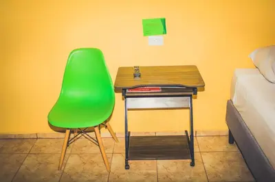 a green chair and a desk in a room with a bed at Cabinas Cóbano - Florida in Tambor