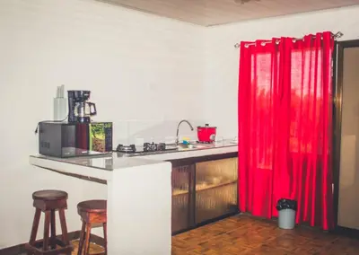 a kitchen with a counter and a red curtain at Villas Antomar in Puntarenas