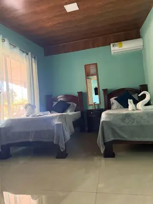a bedroom with two beds and a mirror on the wall at Casas DiTi in Santa Cruz