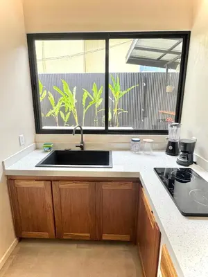 a kitchen with a sink and a large window at Private Tail House centre Uvita in Uvita