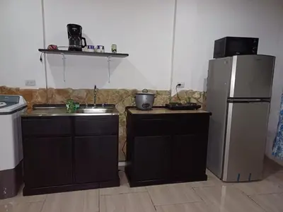 a kitchen with a sink and a refrigerator at Sol De Fati in Quepos