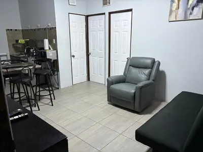 a living room with a chair and a table at Schultz Apartamento in Alajuela City