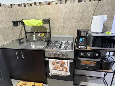 a kitchen with a stove top oven next to a sink at Schultz Apartamento in Alajuela City