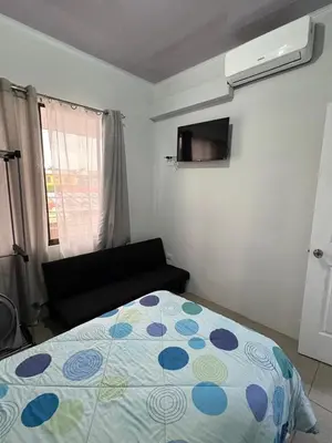 a bedroom with a bed and a couch in it at Schultz Apartamento in Alajuela City