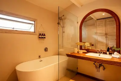 a bathroom with a tub and a sink and a mirror at Casa Bismarkia in Santa Teresa Beach