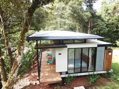 a tiny house in the woods with a deck at Casita Jungle Nest non active in Matapalo