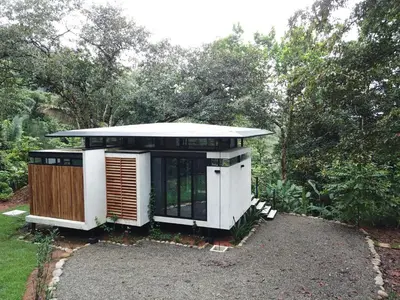 a small house sitting on top of a gravel yard at Casita Jungle Nest non active in Matapalo