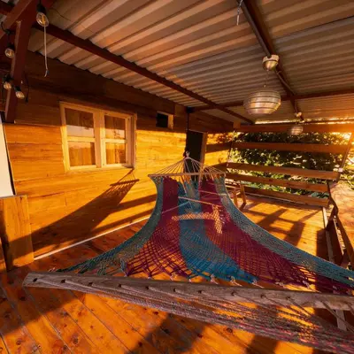 a hammock in the back of a house at Bus Glamping near La Fortuna with Private Jacuzzi & Breakfast in Santa Clara