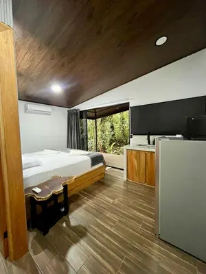 a bedroom with a large bed and a kitchen at Arenal Rocks in Fortuna