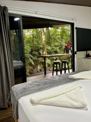 a bedroom with a bed and a large glass window at Arenal Rocks in Fortuna