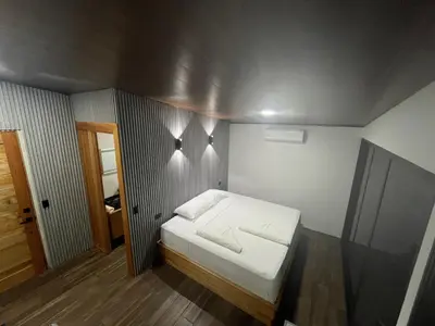 a small bedroom with a white bed in it at Arenal Rocks in Fortuna