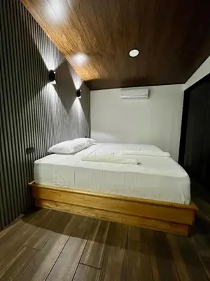 a bedroom with a large bed with a wooden headboard at Arenal Rocks in Fortuna